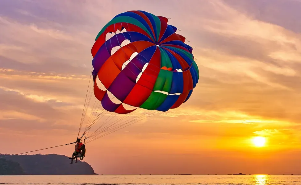 Penunggang parasailing di atas laut ketika waktu keemasan di Langkawi